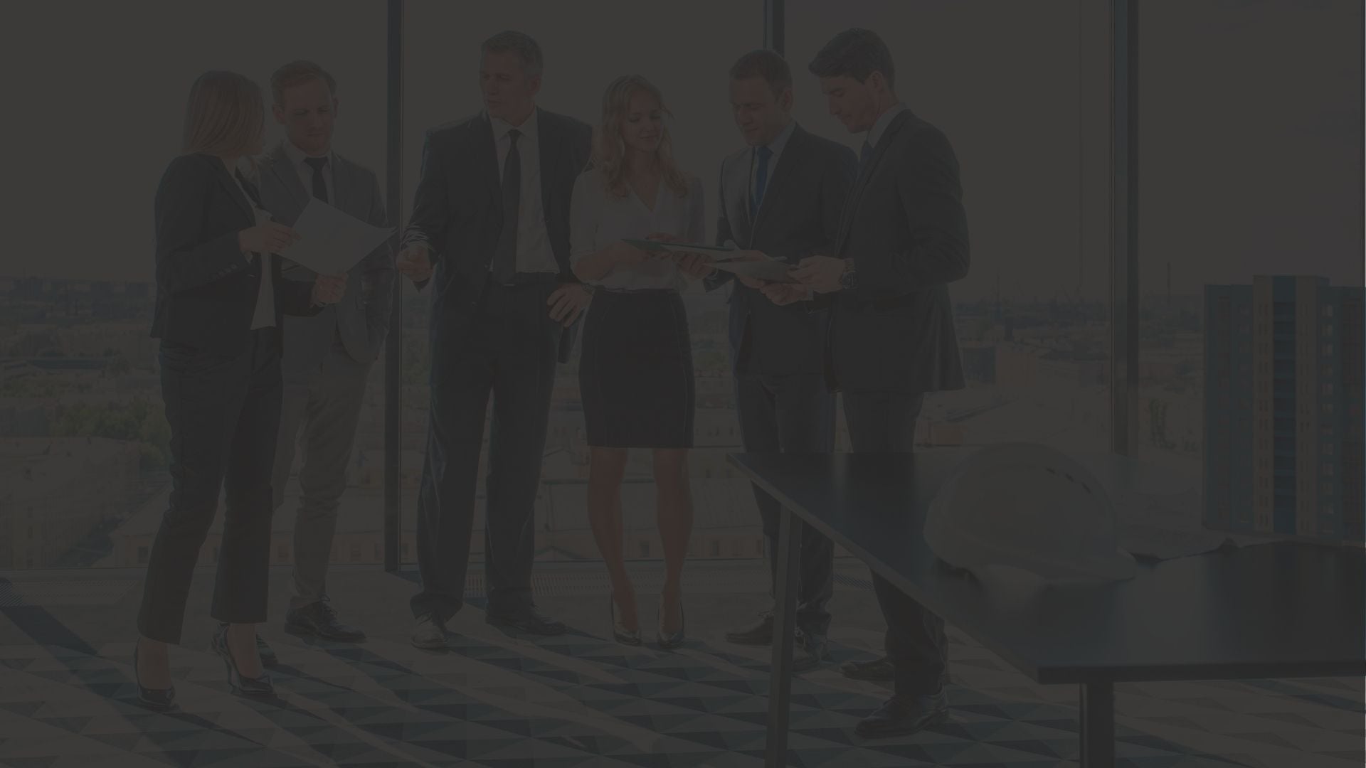 Group of people in business attire discussing plans on a beach.